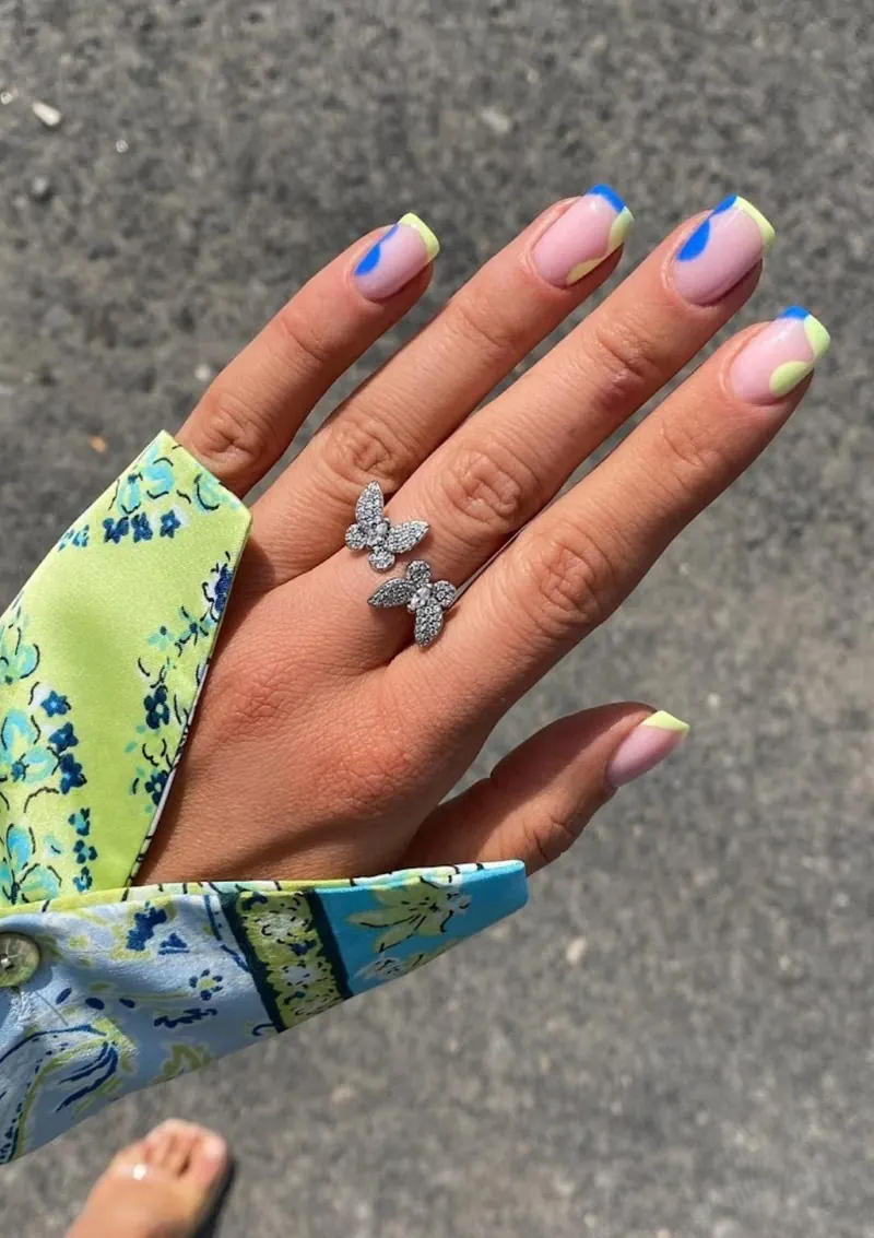 Colourful French nail art with a butterfly ring