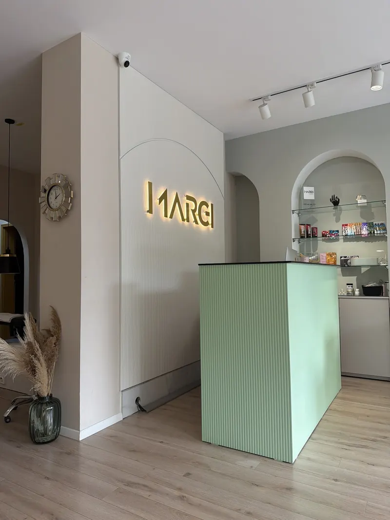 Reception with the illuminated Marei sign and a mint-green desk