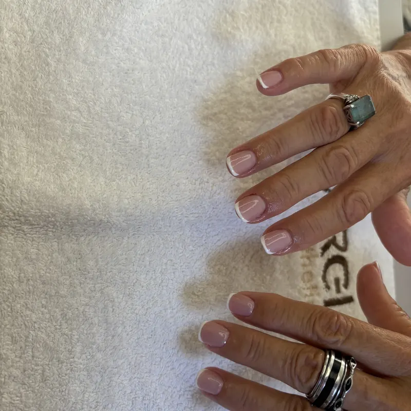 Two hands with fresh French manicures on a Marei towel